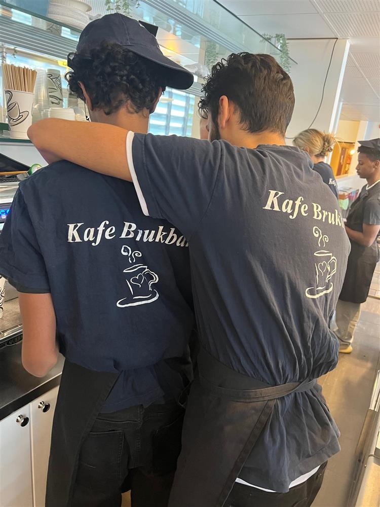 Elver med ryggen til har på t-skjorter med Kafe Brukbar logo - Klikk for stort bilde