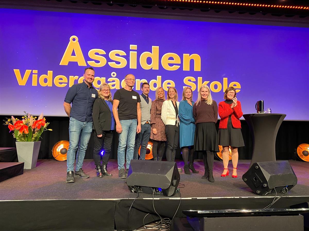 representanter fra Åssiden vgs tar i mot Akan-pris på en scene - Klikk for stort bilde