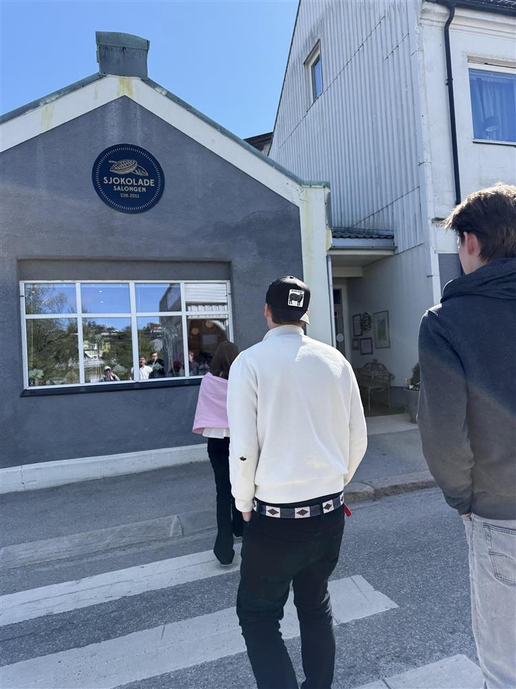 Tre personer med ryggen til utenfor et hus - Klikk for stort bilde