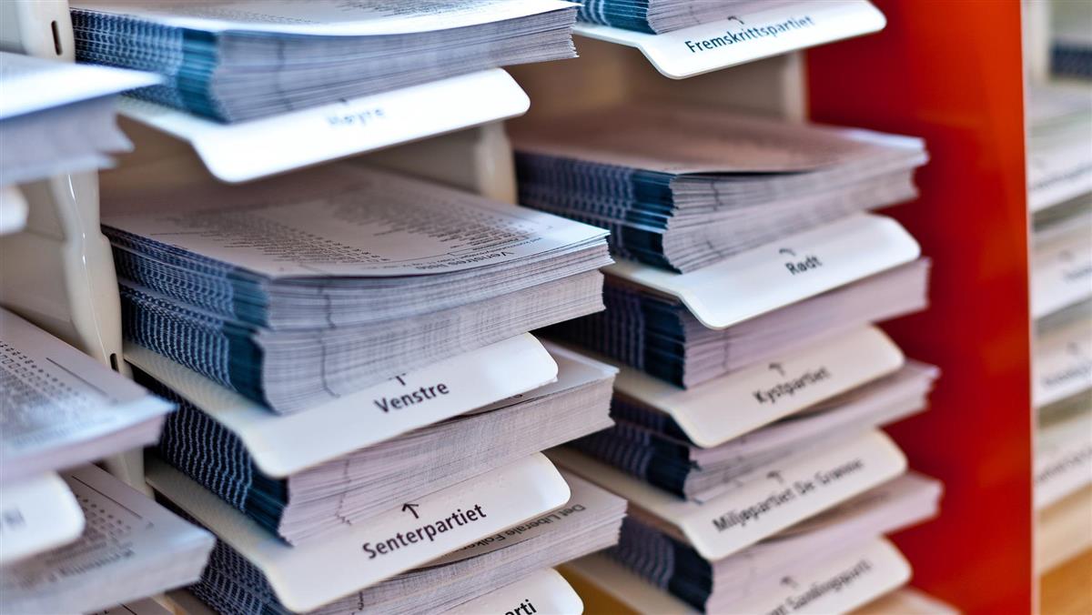 Valglister fra ulike partier ligger i hyller - Klikk for stort bilde