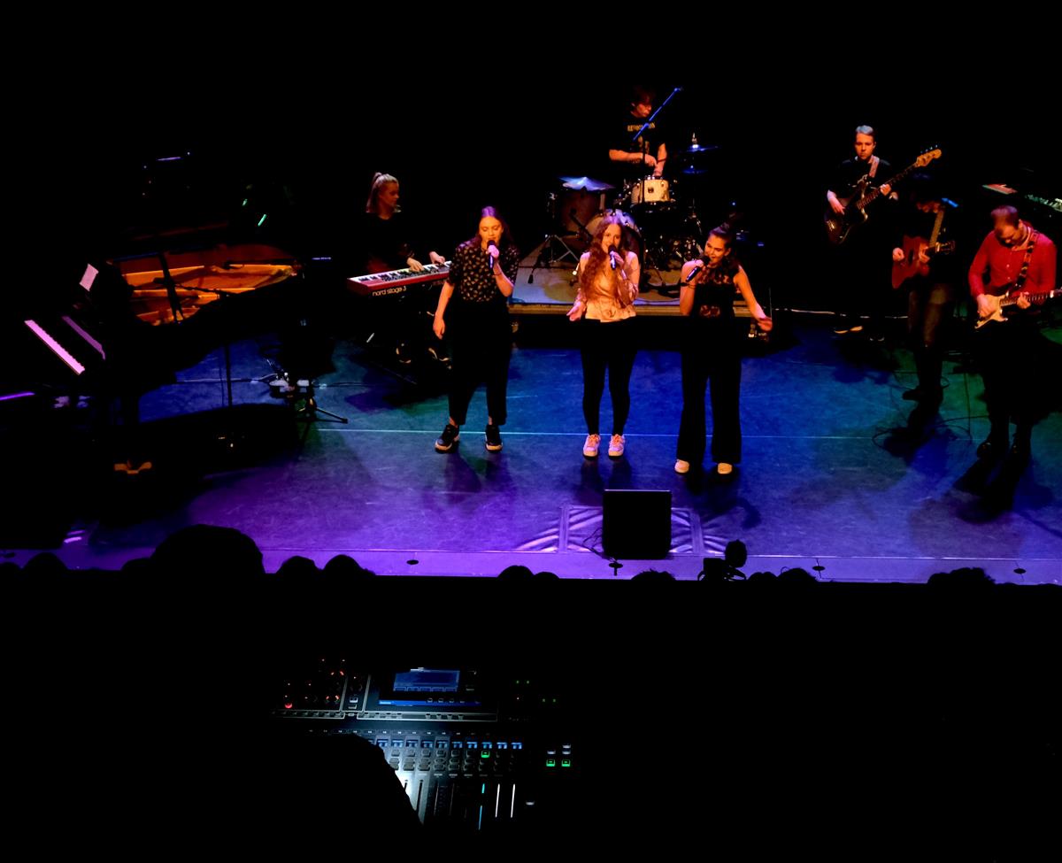 Tre vokalister fremfører en sang under konsert på hovedscenen.  - Klikk for stort bilde